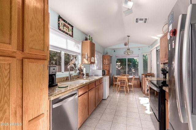 kitchen with sink, vaulted ceiling, hanging light fixtures, light tile patterned floors, and appliances with stainless steel finishes