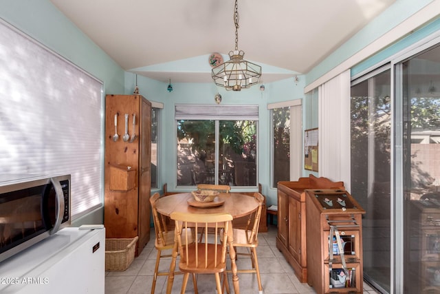 tiled dining space with lofted ceiling