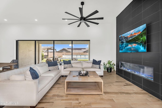 20716 E Pummelos Rd, Queen Creek, AZ 85142 - living area featuring wood finished floors, recessed lighting, a fireplace, a ceiling fan, and a high ceiling