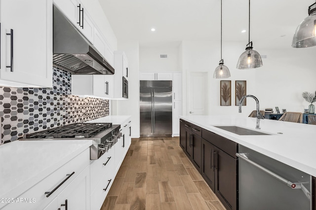 20716 E Pummelos Rd, Queen Creek, AZ 85142 - kitchen featuring built in appliances, under cabinet range hood, light countertops, white cabinets, and recessed lighting