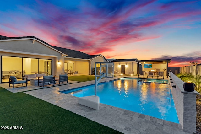 20716 E Pummelos Rd, Queen Creek, AZ 85142 - pool at dusk featuring an outdoor hangout area, a patio area, and a pool with connected hot tub