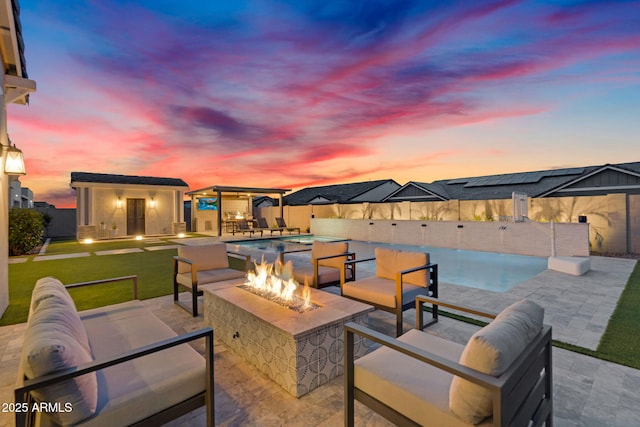 20716 E Pummelos Rd, Queen Creek, AZ 85142 - patio terrace at dusk with a patio area, an outdoor living space with a fire pit, an outbuilding, a fenced backyard, and a pool with connected hot tub