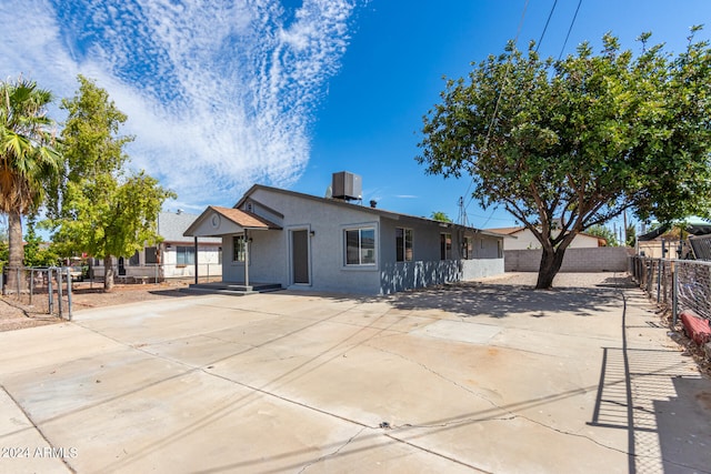 rear view of property with a patio and central AC