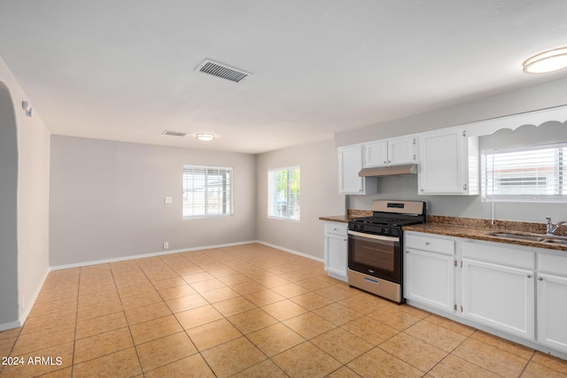 kitchen with stainless steel range with gas cooktop, white cabinetry, sink, and light tile patterned floors