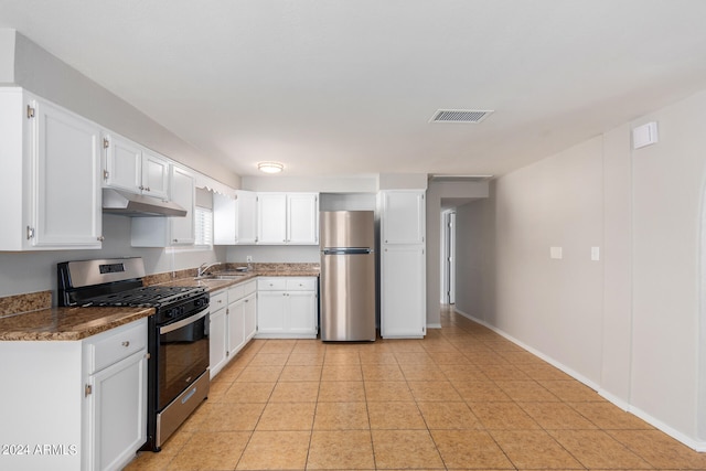 kitchen featuring sink, appliances with stainless steel finishes, light tile patterned floors, and white cabinetry