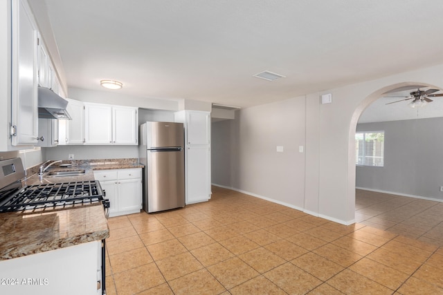 kitchen with white cabinetry, light stone counters, stainless steel appliances, ceiling fan, and sink