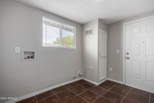 clothes washing area with dark tile patterned flooring, hookup for a gas dryer, and hookup for a washing machine