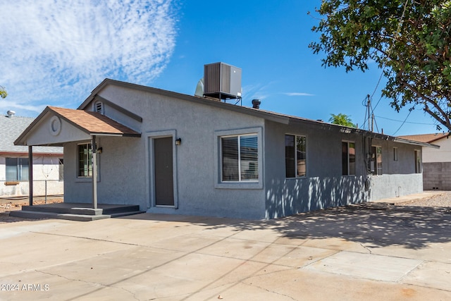 view of front of home featuring cooling unit and a patio