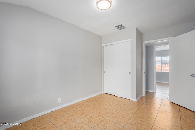 unfurnished bedroom with a closet and light tile patterned floors