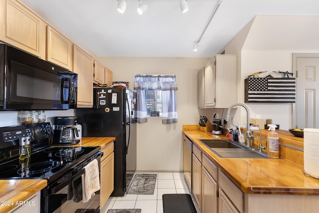 kitchen featuring butcher block counters, black appliances, sink, and rail lighting