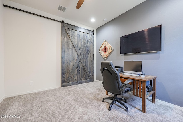 office space with ceiling fan, carpet, and a barn door