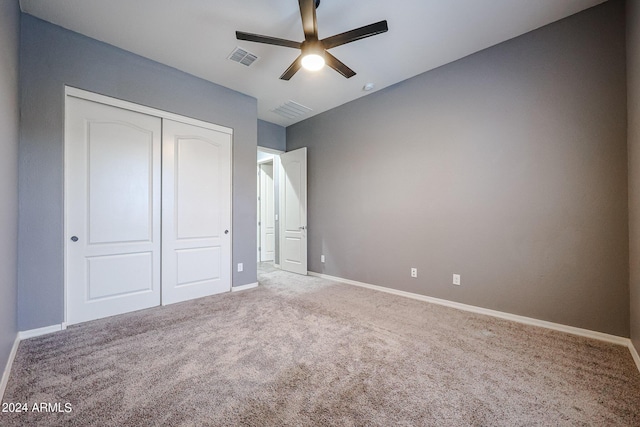 unfurnished bedroom with ceiling fan, carpet, and a closet