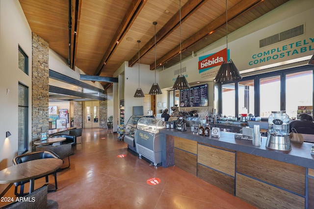 interior space with wooden ceiling, a high ceiling, hanging light fixtures, and beamed ceiling