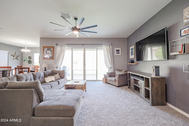 living room with ceiling fan with notable chandelier and carpet