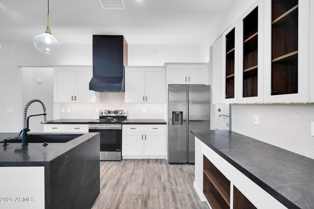 22548 W Huntington Dr, Buckeye, AZ 85326 - kitchen featuring appliances with stainless steel finishes, wall chimney range hood, a sink, dark countertops, and decorative backsplash