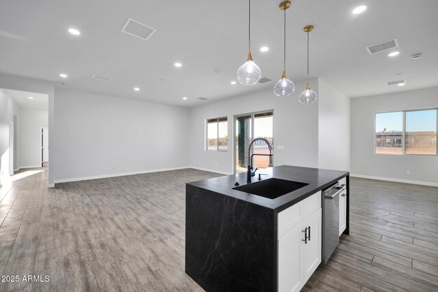 22548 W Huntington Dr, Buckeye, AZ 85326 - kitchen with open floor plan, a sink, stainless steel dishwasher, dark countertops, and healthy amount of natural light