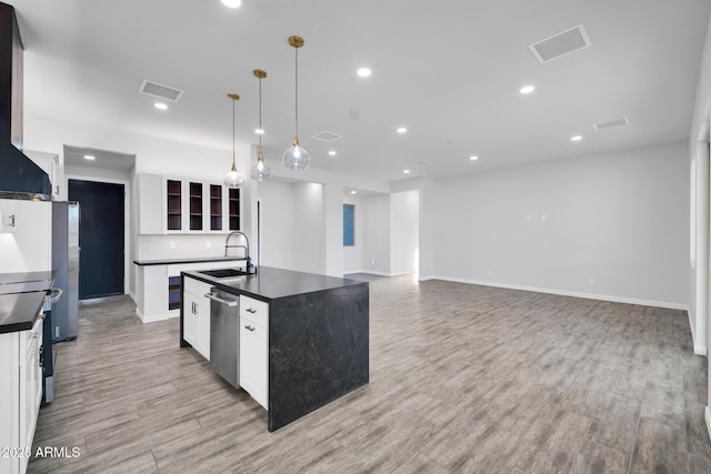 22548 W Huntington Dr, Buckeye, AZ 85326 - kitchen featuring dark countertops, a sink, an island with sink, stainless steel appliances, and light wood-type flooring