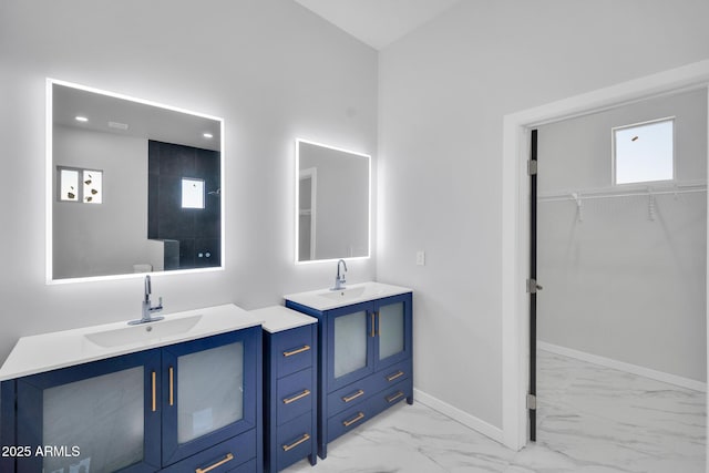 22548 W Huntington Dr, Buckeye, AZ 85326 - bathroom with marble look tiles, baseboards, two vanities, a spacious closet, and recessed lighting