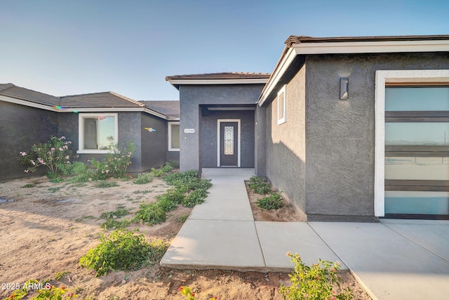 22548 W Huntington Dr, Buckeye, AZ 85326 - view of exterior entry with stucco siding and a tiled roof