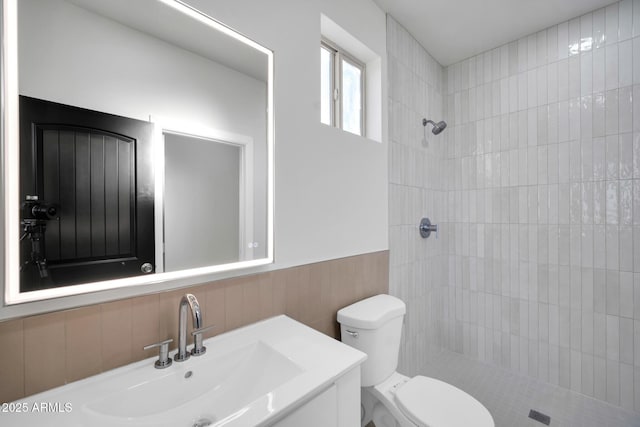22548 W Huntington Dr, Buckeye, AZ 85326 - bathroom featuring a tile shower, toilet, vanity, and wainscoting