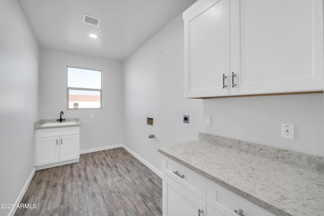 22548 W Huntington Dr, Buckeye, AZ 85326 - clothes washing area with hookup for an electric dryer, cabinet space, wood finished floors, and baseboards