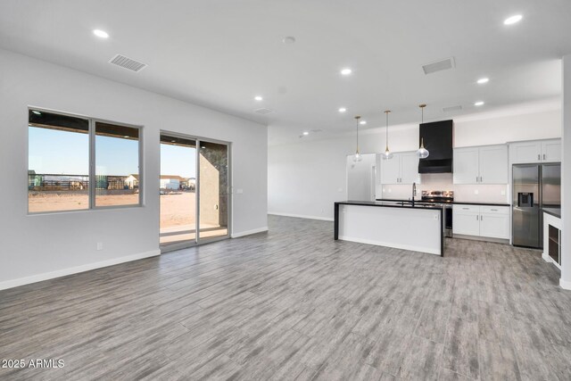 22548 W Huntington Dr, Buckeye, AZ 85326 - unfurnished living room with a sink, recessed lighting, baseboards, and light wood-type flooring