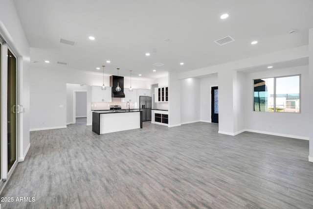 22548 W Huntington Dr, Buckeye, AZ 85326 - unfurnished living room featuring recessed lighting, baseboards, light wood-style flooring, and a sink