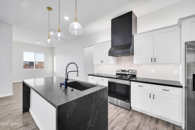 22548 W Huntington Dr, Buckeye, AZ 85326 - kitchen with appliances with stainless steel finishes, a sink, wall chimney range hood, backsplash, and light wood-style floors