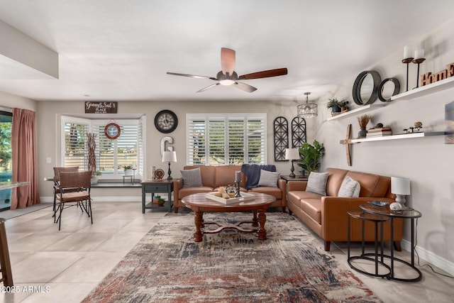 living room with ceiling fan, light tile patterned floors, baseboards, and a healthy amount of sunlight