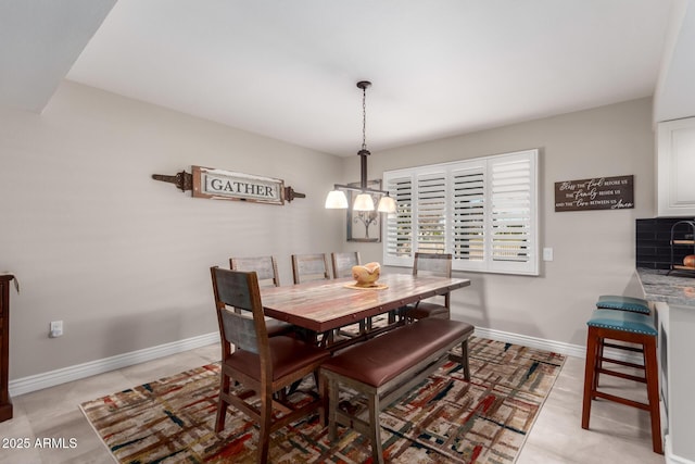 dining room with a chandelier and baseboards