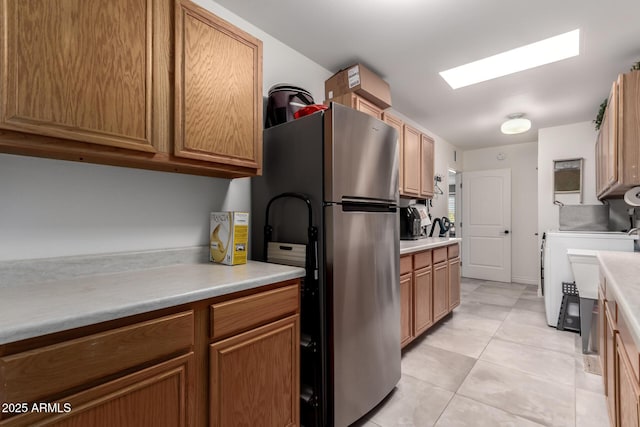 kitchen with light countertops, a skylight, and freestanding refrigerator