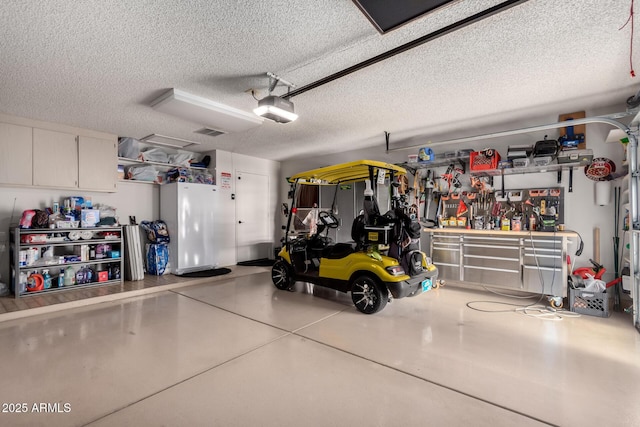 garage with visible vents, a workshop area, and a garage door opener