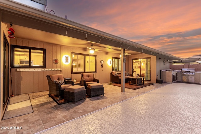 view of patio featuring exterior kitchen, ceiling fan, grilling area, and an outdoor hangout area