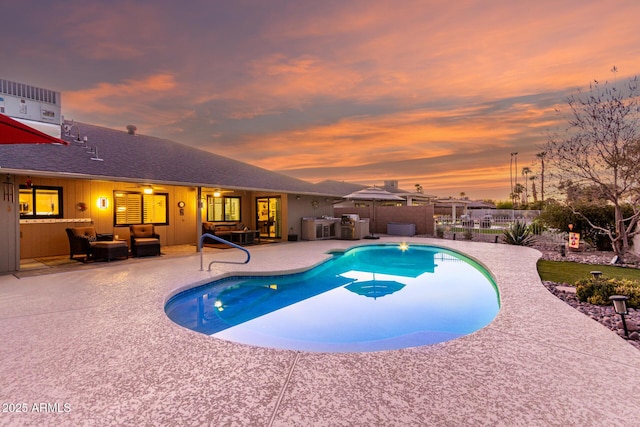 pool at dusk with an outdoor hangout area, a patio area, fence, and a fenced in pool