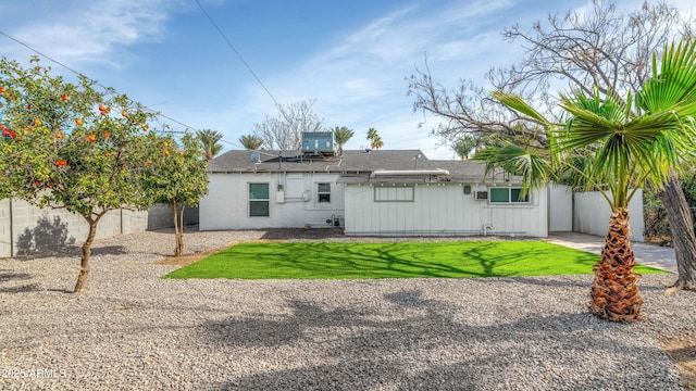 rear view of house with a yard and central AC