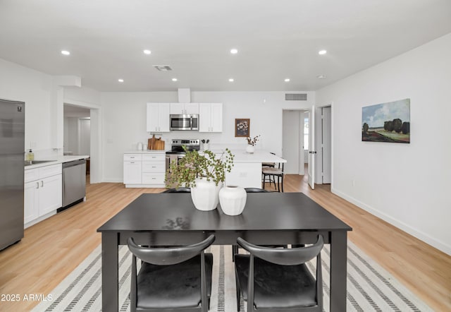 dining room with sink and light hardwood / wood-style flooring