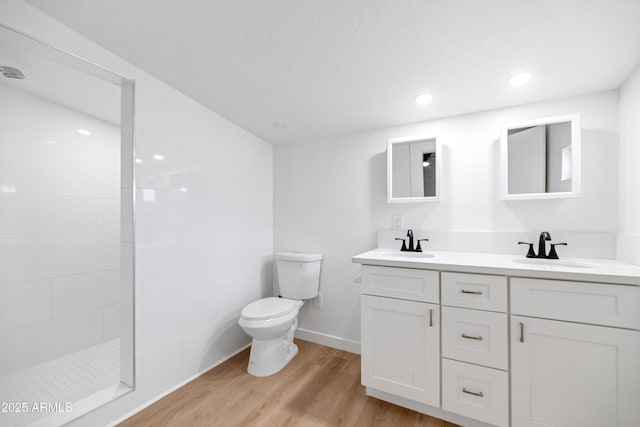 bathroom featuring vanity, hardwood / wood-style flooring, a shower, and toilet