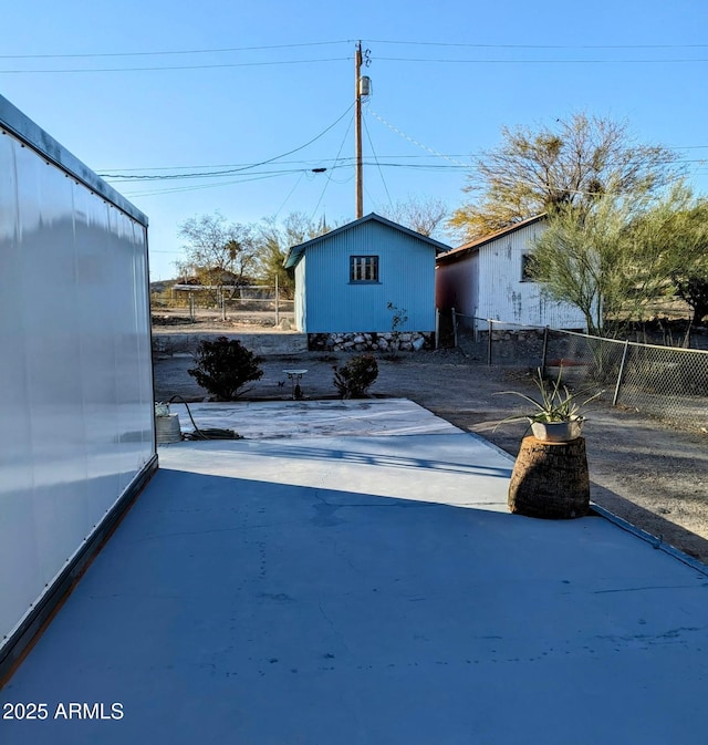 view of yard featuring an outbuilding, a patio area, and fence