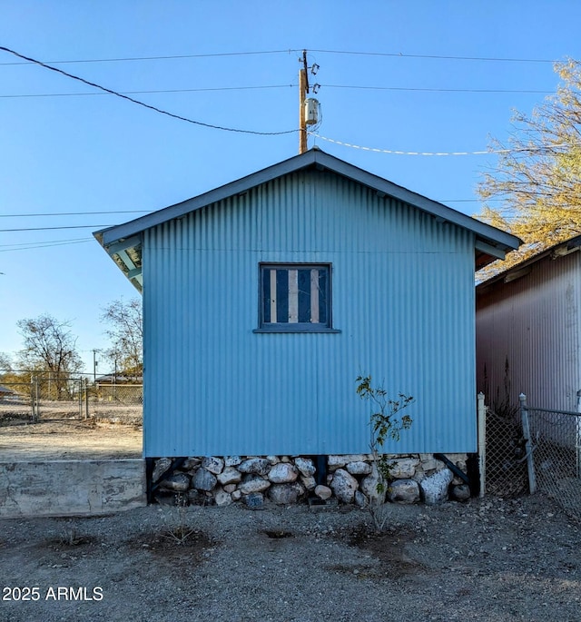 view of side of property featuring an outdoor structure and fence