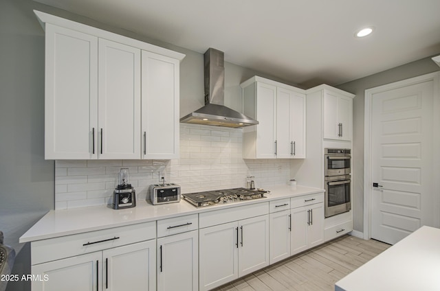 12806 W Mclellan Rd, Glendale, AZ 85307 - kitchen featuring wall chimney exhaust hood, stainless steel appliances, white cabinetry, decorative backsplash, and recessed lighting