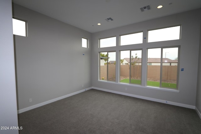 unfurnished room with dark colored carpet