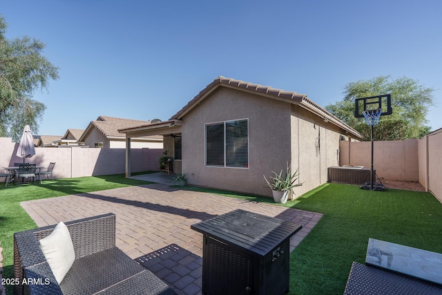 rear view of property featuring a fenced backyard, a patio, stucco siding, and a yard