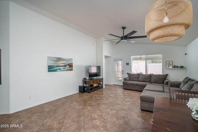 living area with ceiling fan, baseboards, and high vaulted ceiling