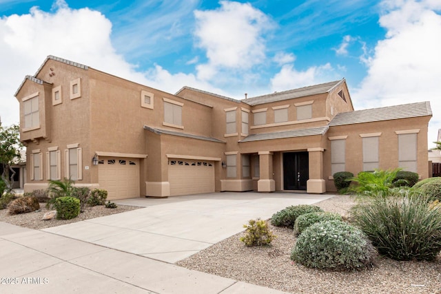 view of front of home with a garage, driveway, and stucco siding