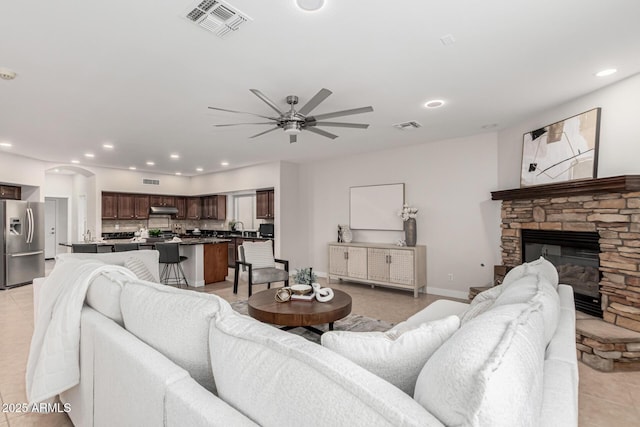 living room featuring recessed lighting, visible vents, a stone fireplace, and light tile patterned floors