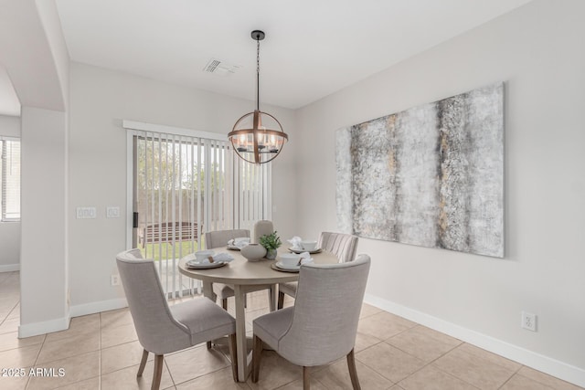 dining area featuring baseboards, light tile patterned floors, visible vents, and a notable chandelier