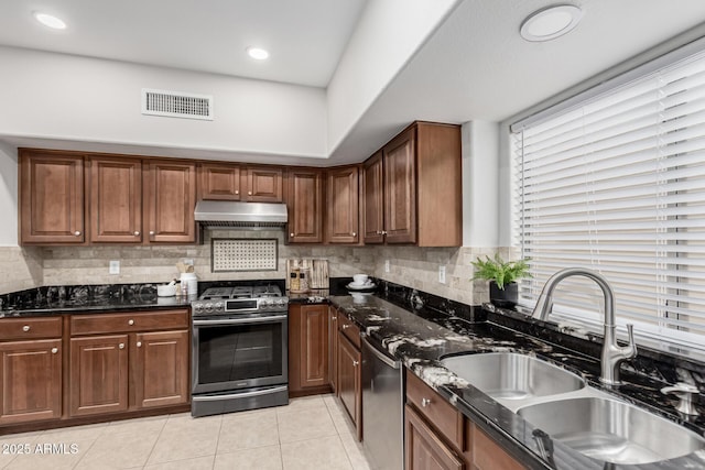 kitchen with tasteful backsplash, visible vents, appliances with stainless steel finishes, under cabinet range hood, and a sink