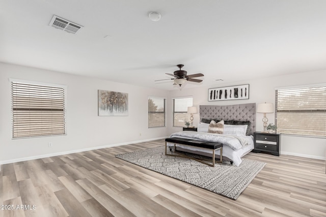 bedroom featuring visible vents, ceiling fan, baseboards, and wood finished floors