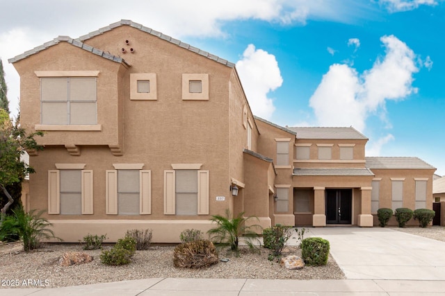 view of front of house with a tiled roof and stucco siding