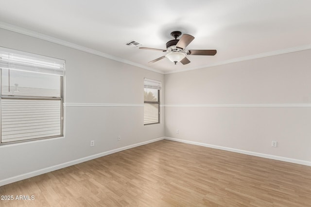 spare room featuring visible vents, baseboards, a ceiling fan, light wood-style flooring, and crown molding